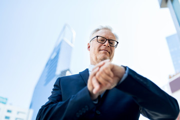 Poster - senior businessman checking time on his wristwatch