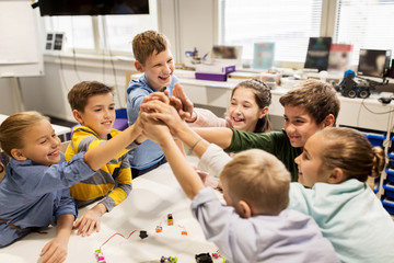 Wall Mural - happy children making high five at robotics school