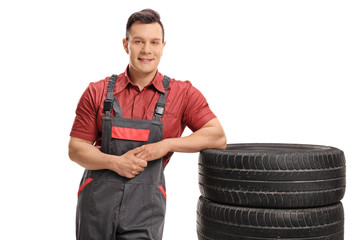 Canvas Print - Mechanic leaning on a stack of tires