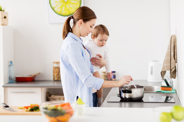 happy mother and baby cooking at home kitchen