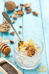 Wall Mural - Healthy dietary breakfast - chia pudding with muesli, cereal flakes, walnut and honey in a glass bowl