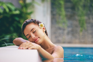 Beauty and body care. Sensual young woman relaxing in outdoor spa swimming pool.