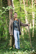 © bokan - Handsome young man with retro camera is hiking in a forest