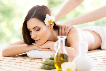 Young and beautiful girl relaxing in spa salon. Massage therapy over seasonal summer or spring background. Healing medicine and health care concept.