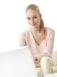 © sepy - Shot of a beautiful young woman using her laptop while sitting at isolated white background with copy space.