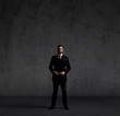 © Acronym - Businessman standing over dark wall background. Business, career job concept.