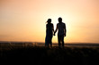 Young couple walking forward to sunset
