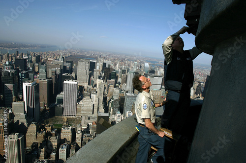 Workers Replace A Light Fixture On The 103rd Floor Of The