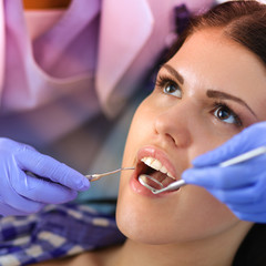 Wall Mural - Woman dentist working at her patient  teeth