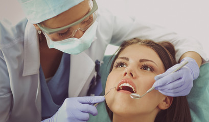 Wall Mural - Woman dentist working at her patient&amp;amp;#39;s teeth