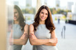 © elnariz - Arms crossed folded pretty woman standing, living the city life, skyline background, genuine smile