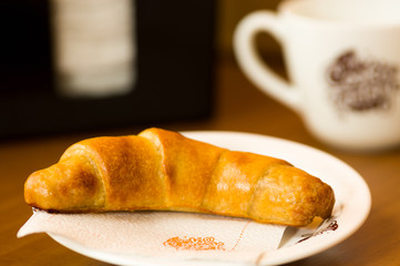 Delicious fresh baked croissants on plate with a wooden background