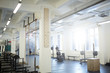 © pressmaster - Background image of various equipment in gym: exercise stands with climbing rope and barbell benches in empty sunlit hall