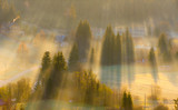 Fototapeta  - Sunset in the mountains with rays of light and mist