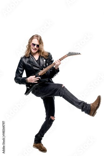 Valokuva handsome rocker in sunglasses posing playing electric guitar isolated on white,