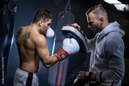 Leinwand Poster Male boxer learning with coach