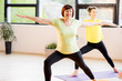 © rh2010 - Young and older women in sports wear doing yoga together indoors at home or a gym