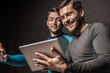 © LIGHTFIELD STUDIOS - Handsome young men using tablet computer together