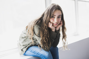 Wall Mural - Teenager girl sitting on window