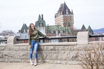 Quebec City scape with Chateau Frontenac and young teen enjoying the view.