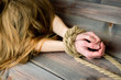 redhead skinny woman bounded with rope, hands close-up. Copy space