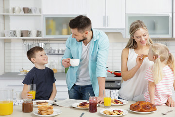 Wall Mural - Happy family having breakfast on kitchen