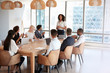 © Monkey Business - Businesswoman Stands To Address Meeting Around Board Table