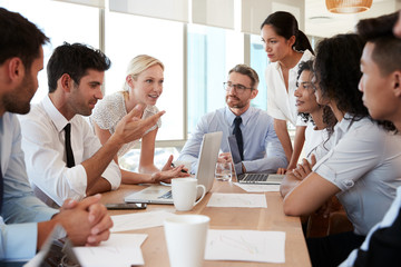 group of businesspeople meeting around table in office