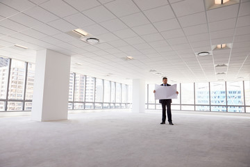 Wall Mural - Male Architect In Modern Empty Office Looking At Plans