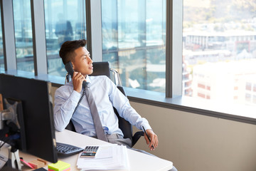 Wall Mural - Businessman Making Phone Call Sitting At Desk In Office