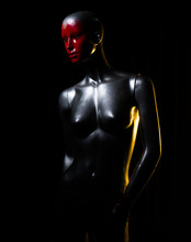 Silver Female Fashion Mannequin With Red Face Over Black Background