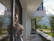 woman drinking coffee in front of her luxury home villa