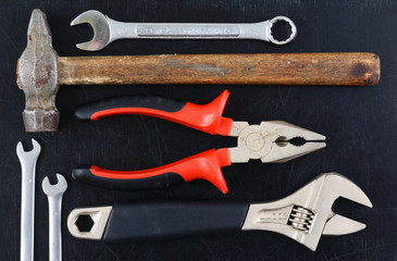 Tools manual hardware on black board.