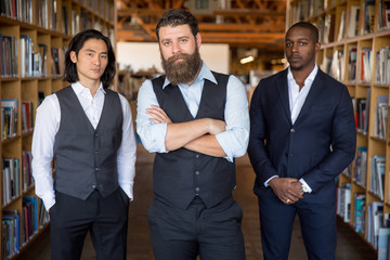 Wall Mural - Team of modern male business men standing looking stylish at the work place before a meeting