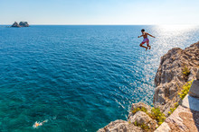 A Boy Is Jumping From The Cliff. Holidays In Montenegro