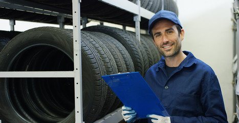 Wall Mural - Specialist auto mechanic in the car service, checks the tire tread, in the background of rubber Concept repair of machines fault diagnosis repair specialist technical maintenance and on-board computer