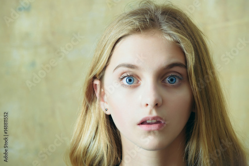 Fotografering beautiful surprised girl on wall background