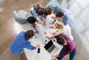 overhead view of professional businesspeople discussing and brainstorming together on workplace in office