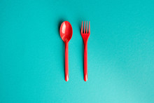 Top View Of Set Of Plastic Fork And Spoon Isolated On Blue