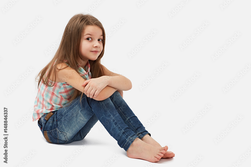 Pretty little girl sitting on the floor, Isolated over white Stock ...