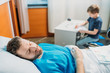 © LIGHTFIELD STUDIOS - son drawing pictures while sick father laying on hospital bed at ward, dad and son