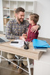 © LIGHTFIELD STUDIOS - Father businessman hugs his son at home office