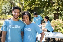 Smiling Volunteers Standing In The Park