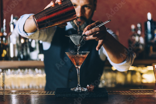 Fotografía Barman is making cocktail at night club.