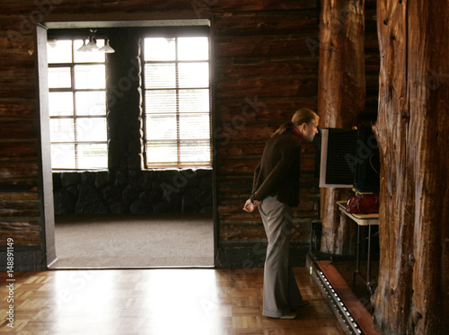 A Woman Looks At Her Ballot At A Polling Place At The Log Cabin At