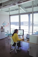 Confident female designer using digitizer on desk in office