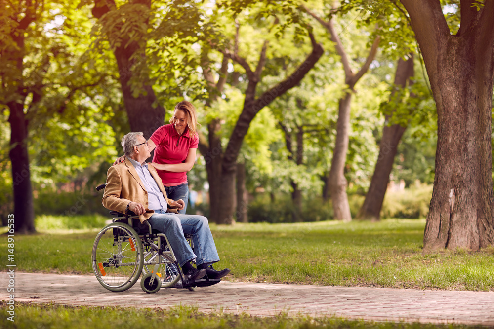 senior man in wheelchair in the park with daughter. - obrazy, fototapety, plakaty 