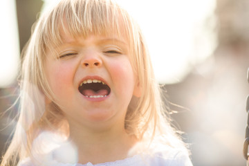 happy smiling young baby caucasian blonde real people girl close outdoor grimacing portrait 