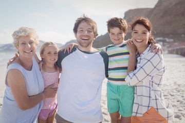 Wall Mural - Portrait of multi-generated family embracing at beach