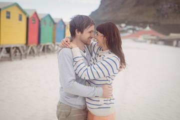 Wall Mural - Smiling couple embracing at beach